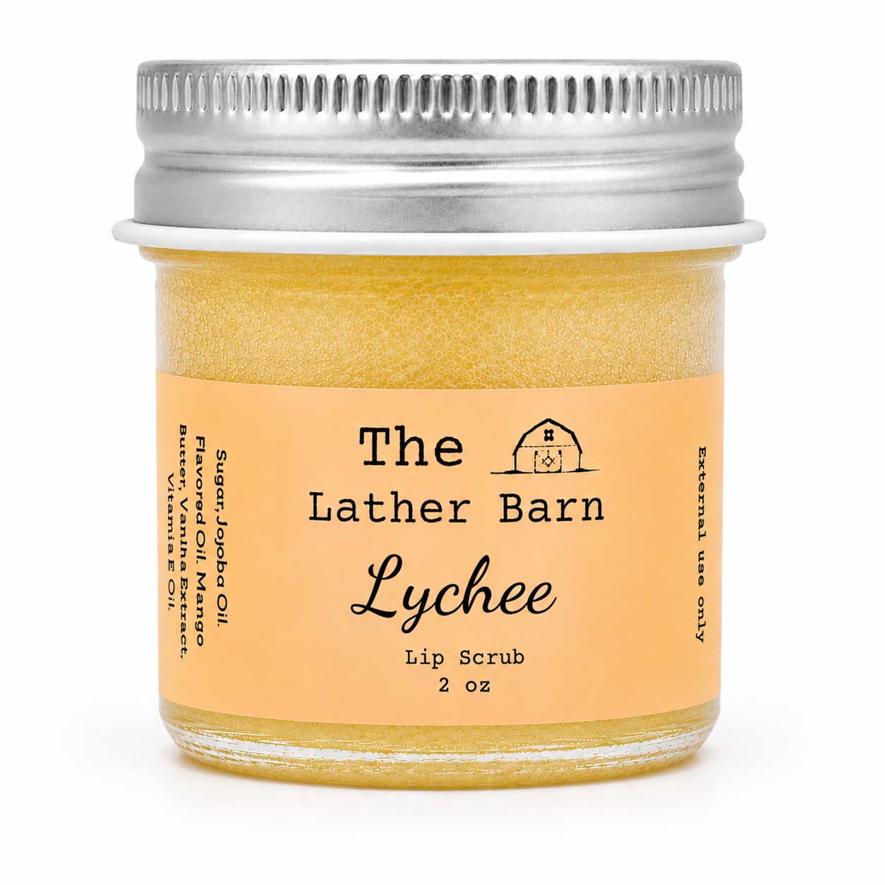 A 2 oz glass jar of The Lather Barn Lychee Lip Scrub, filled with a golden-yellow scrub and featuring a peach-colored label with a silver metal screw cap, set against a plain white background.