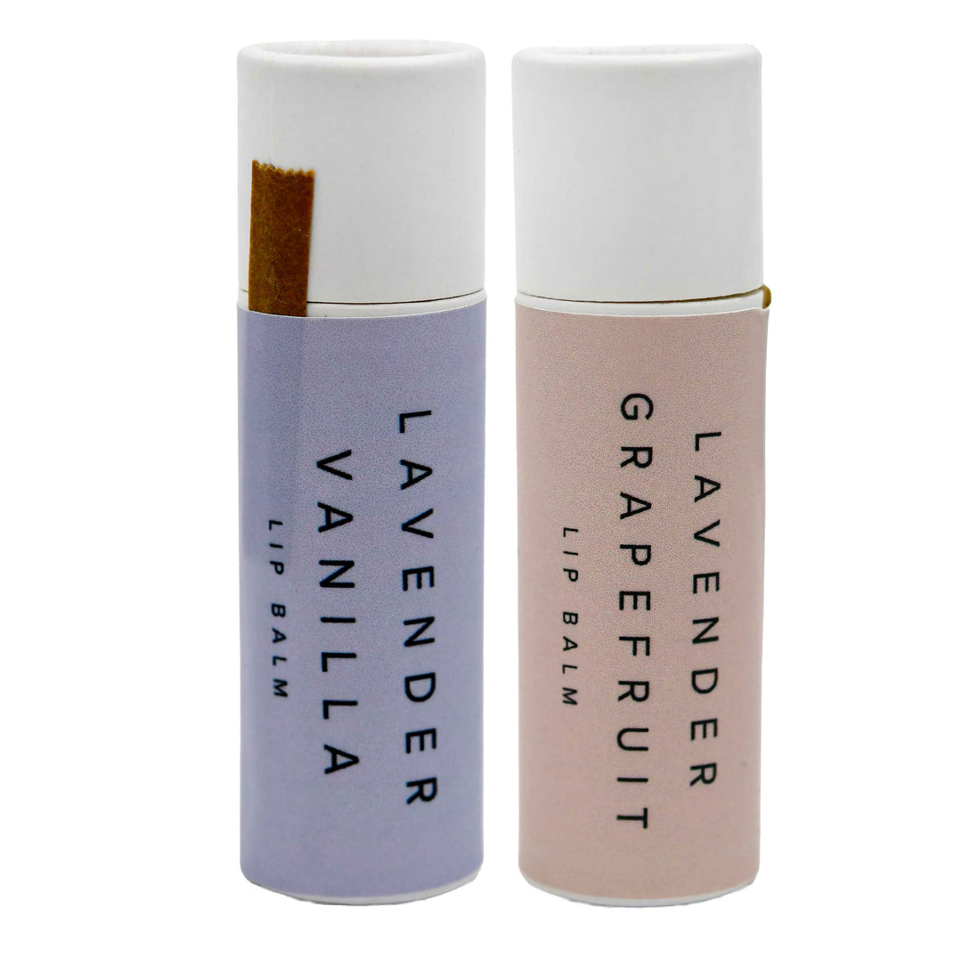 Two lip balm containers, one lavender vanilla and one grapefruit, on a white background.