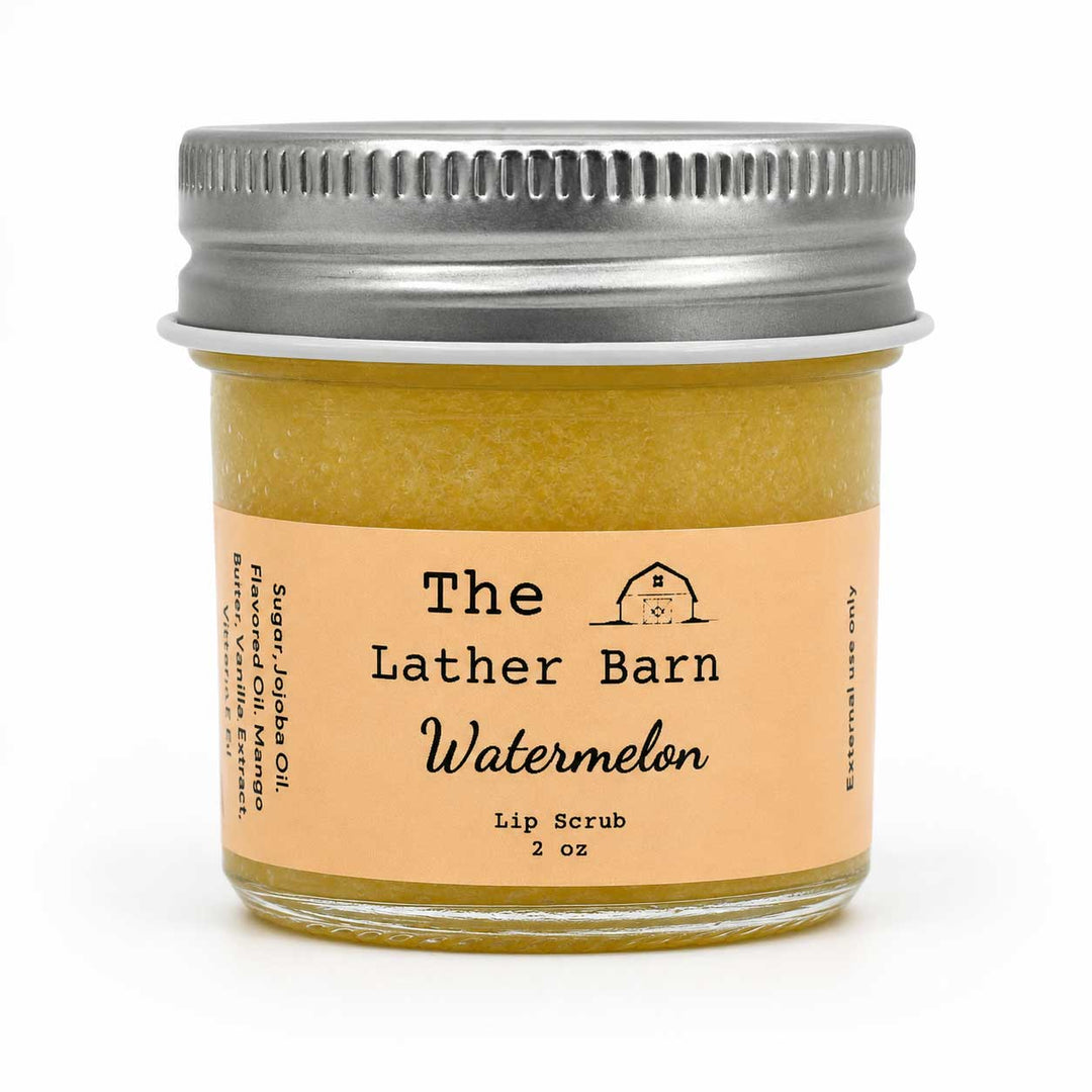 A jar of The Lather Barn Watermelon lip scrub with a silver metal lid and a peach-colored label, set against a plain white background.