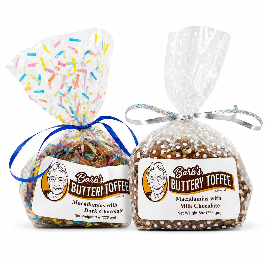 Two bags of Barb's Buttery Toffee on a white background, one with multicolor sprinkles and dark chocolate, and one with milk chocolate and white chocolate chips, both in clear bags with white labels and silver/blue ribbons.