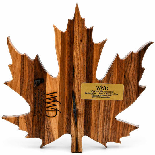 Wooden maple leaf-shaped cutting board with WWD logo on a white background