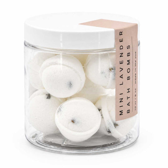 Clear jar with white bath bombs and a pink label on a white background