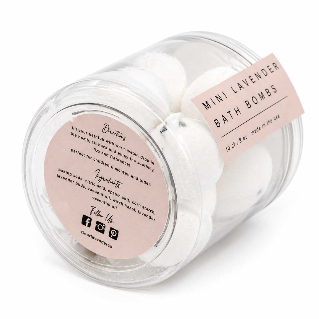Jar of mini lavender bath bombs with pink labels on a white background