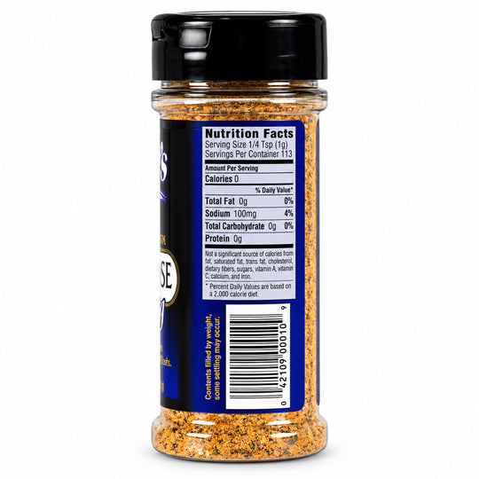 A clear plastic bottle of seasoning with a black lid, showing the back label with nutrition facts and a barcode. The seasoning inside is a coarse blend of orange, brown, and yellow flakes.