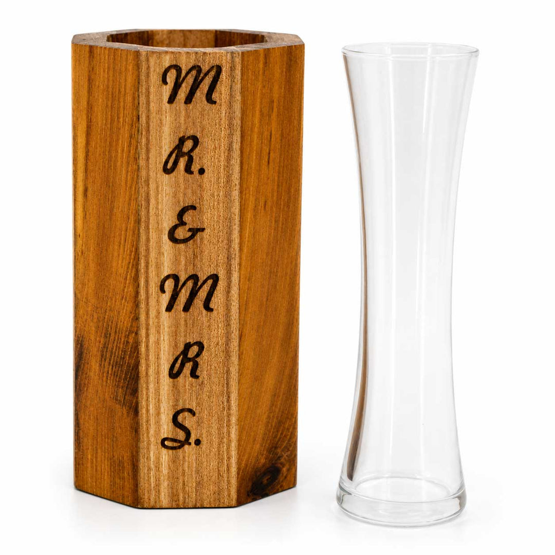Wooden vase with 'Mr. & Mrs.' engraving next to a clear glass vase on a white background