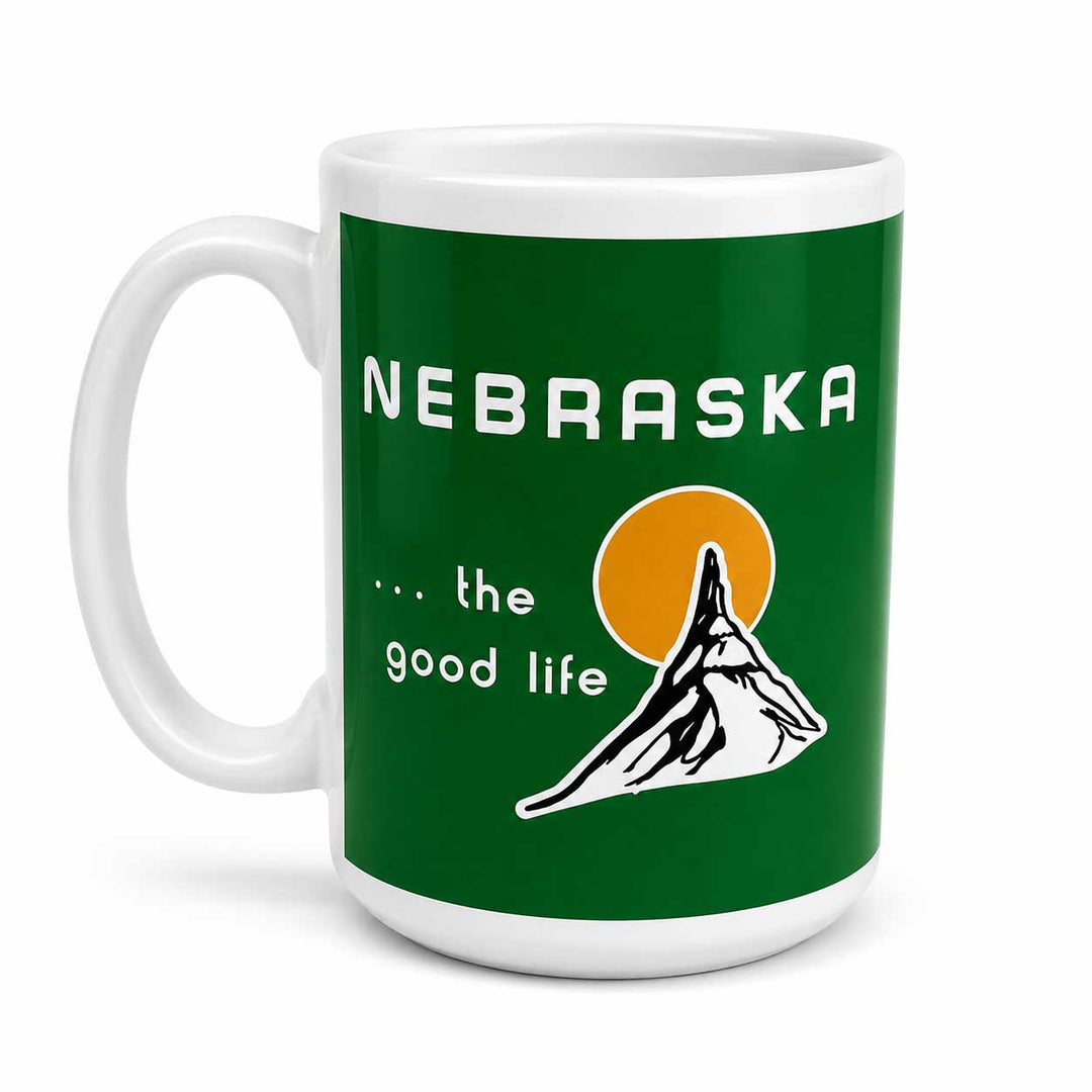 A white ceramic mug featuring a green wraparound graphic with the text 'NEBRASKA .