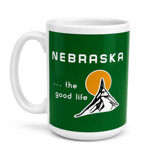 A white ceramic mug featuring a green wraparound graphic with the text 'NEBRASKA .
