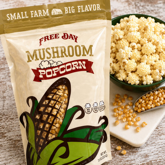 Free Day Mushroom Popcorn package with popcorn and kernels on a wooden surface