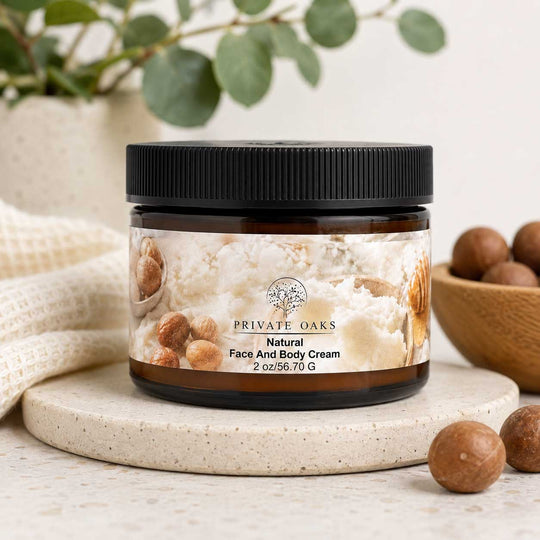 A jar of Private Oaks Natural Face And Body Cream sits on a round stone coaster, styled with macadamia nuts and a neutral fabric background.