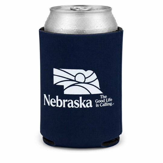 A navy blue neoprene can cooler sleeve with a silver aluminum can inserted, featuring the white Nebraska state outline and the text 'Nebraska The Good Life Is Calling.