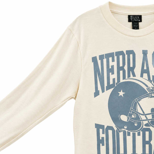 A close-up of a cream-colored long-sleeve t-shirt with a blue graphic print featuring the text 'NERRASKA FOOTBALL' and a football helmet. The neck label shows the brand 'LUX Racing'.