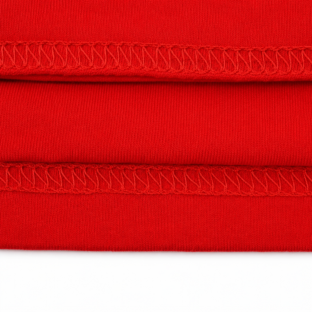 Close-up of red fabric with a visible seam on a white background