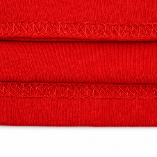 Close-up of red fabric with a visible seam on a white background