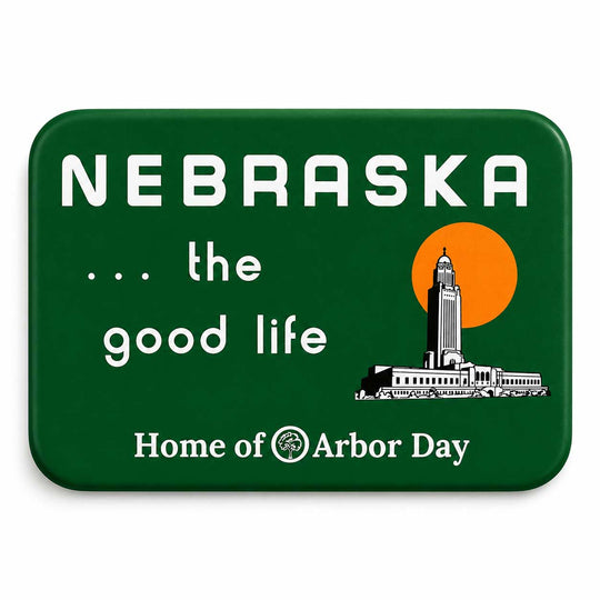 A rectangular green magnet with rounded corners featuring the words “NEBRASKA .