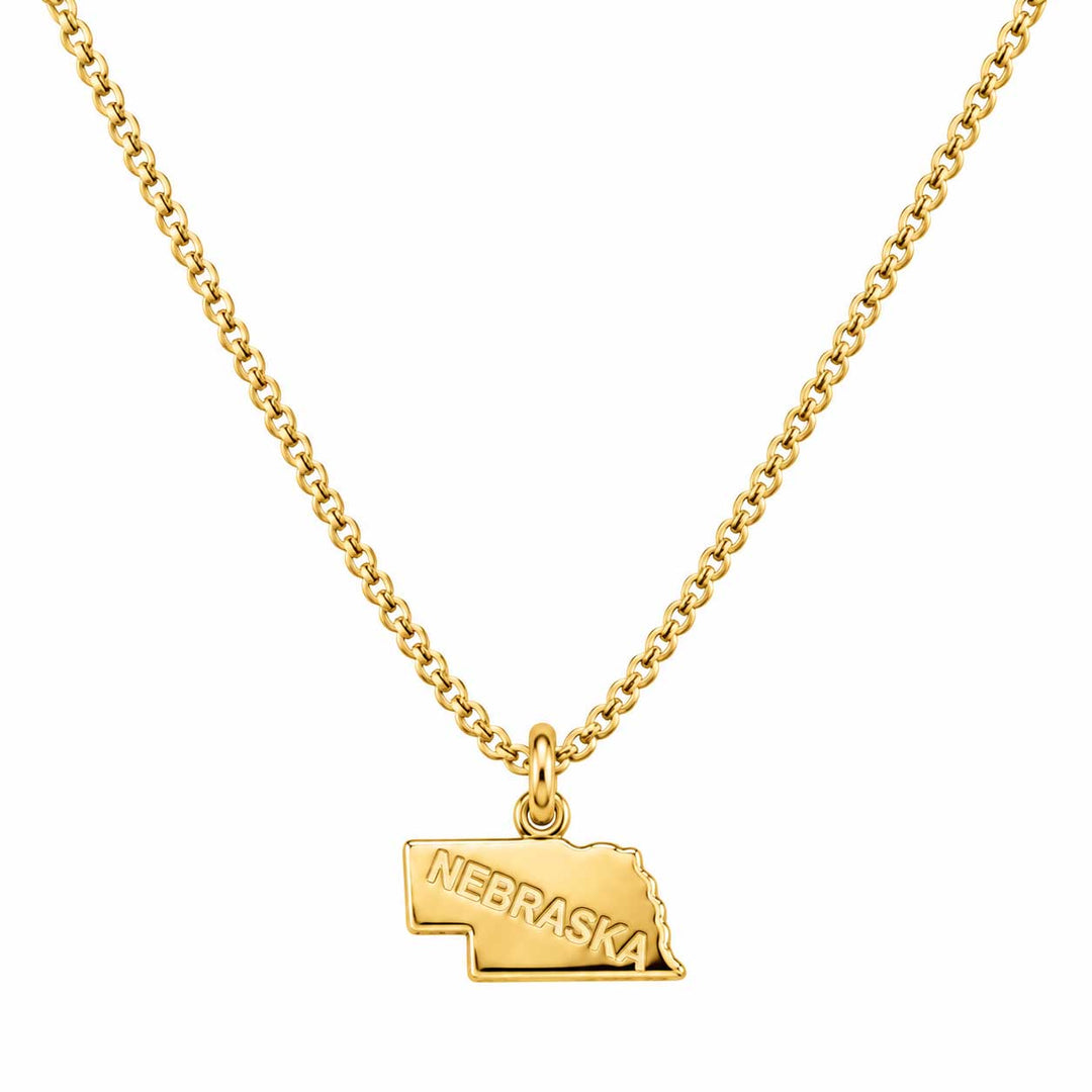 A gold chain necklace featuring a small pendant shaped like the state of Nebraska, with the word 'NEBRASKA' engraved on the front, shown against a plain white background.