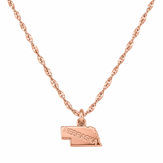 A rose gold necklace featuring a twisted chain and a small pendant shaped like the state of Nebraska, with 'NEBRASKA' engraved on the front, shown against a plain white background.