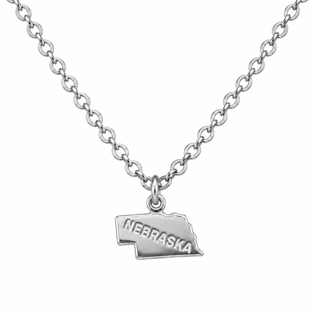 A silver chain necklace featuring a small pendant shaped like the state of Nebraska, with the word 'NEBRASKA' engraved on the front, shown against a plain white background.