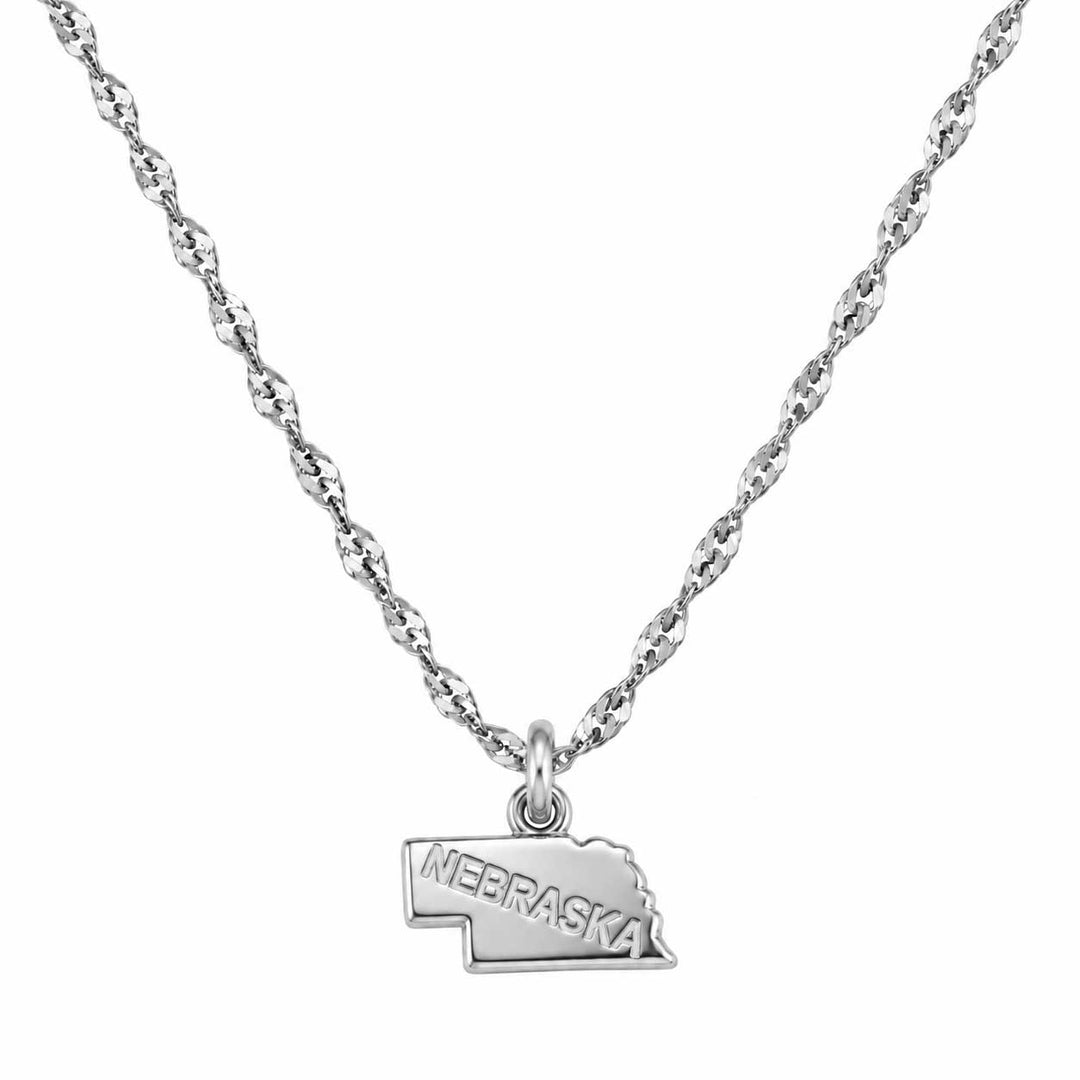 A silver necklace featuring a twisted rope chain and a small pendant shaped like the state of Nebraska, engraved with the word 'NEBRASKA', shown against a plain white background.