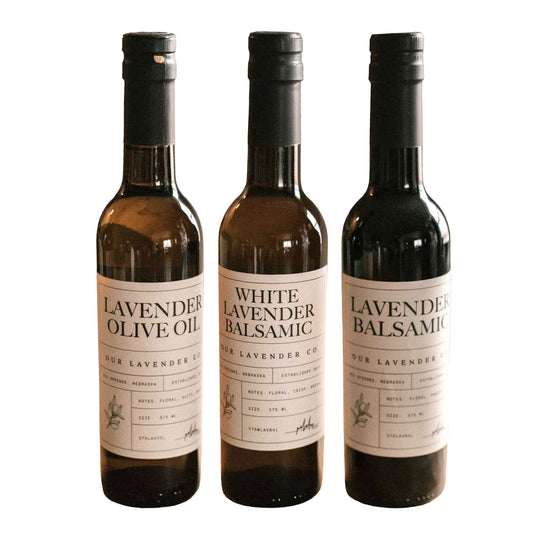 Three bottles of lavender-infused olive oil and balsamic vinegar on a white background