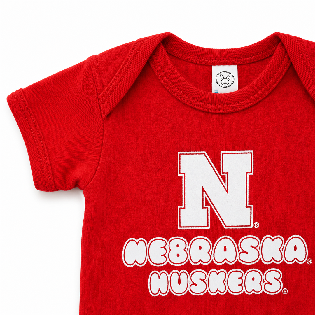 Red baby onesie with 'Nebraska Huskers' text and logo on a white background