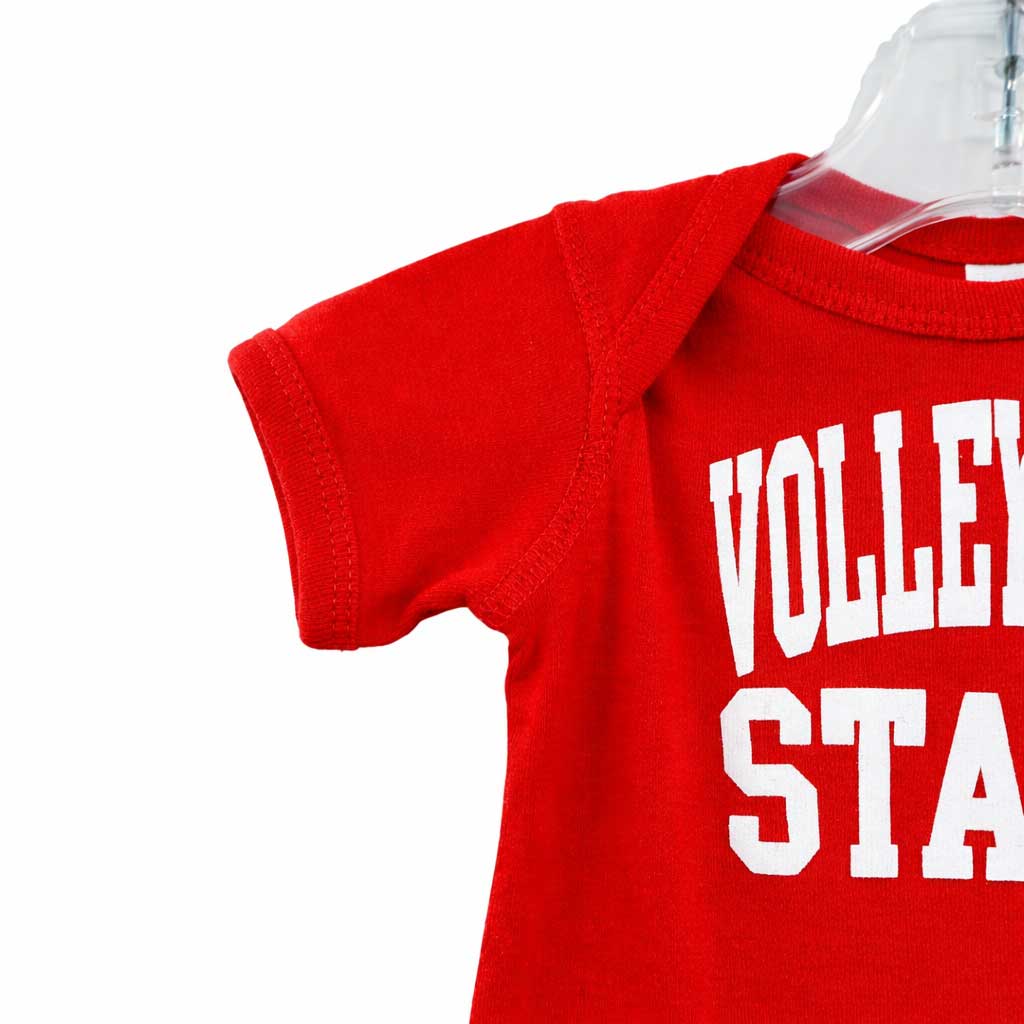 Red baby onesie with 'Volley Star' text on a clear hanger against a white background
