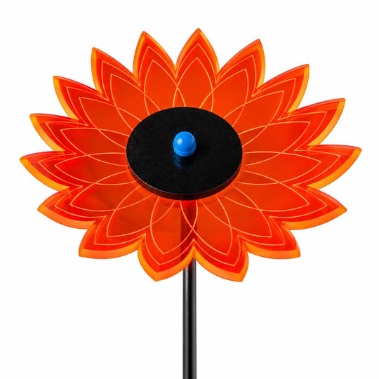 A stylized flower-shaped garden stake with translucent orange-red petals, a black circular center, and a small blue spherical top, shown on a white background.