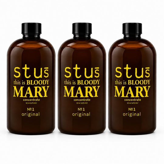Three amber glass bottles with black caps and yellow text reading 'stuć this is BLOODY MARY concentrate' and 'Nċ1 original', shown on a white background.