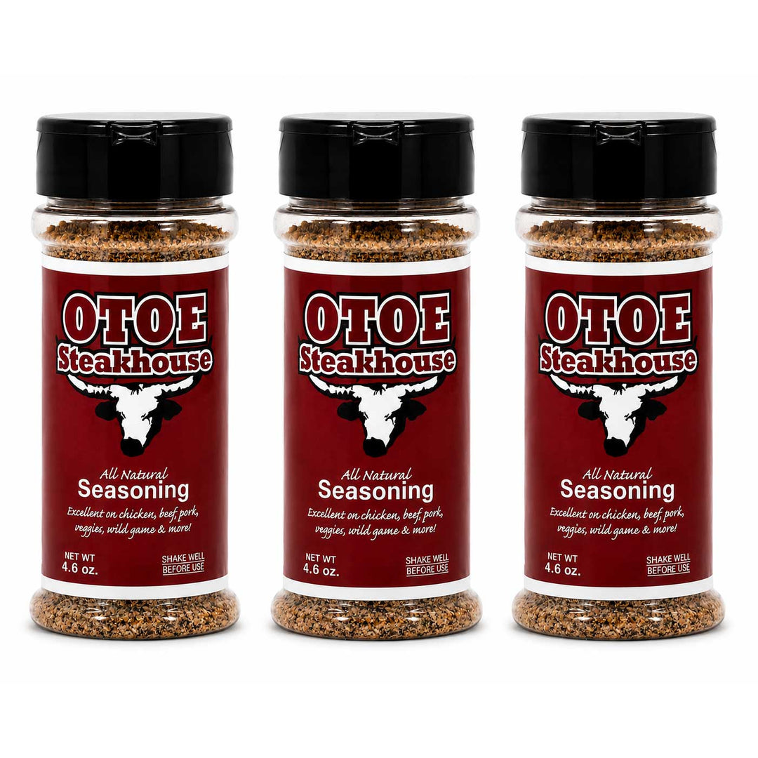 Three clear plastic bottles of Otoe Steakhouse All Natural Seasoning with black flip-top caps, arranged side by side on a white background.