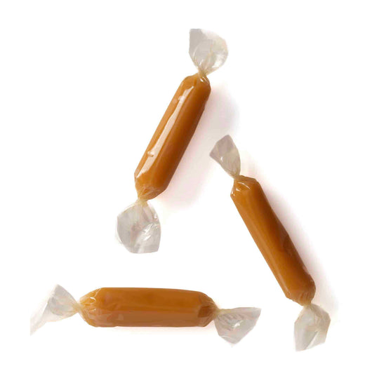 Three wrapped caramels on a white background