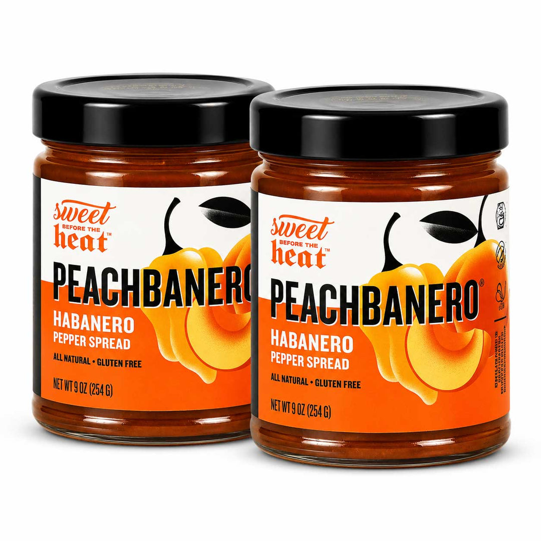 Two glass jars of Sweetener Heat Peachbanano Habanero Pepper Spread on a white background.