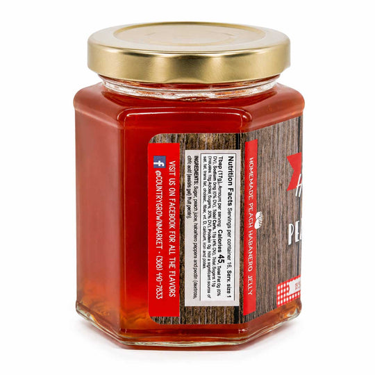 Jar of peach habanero jelly with a gold lid on a white background