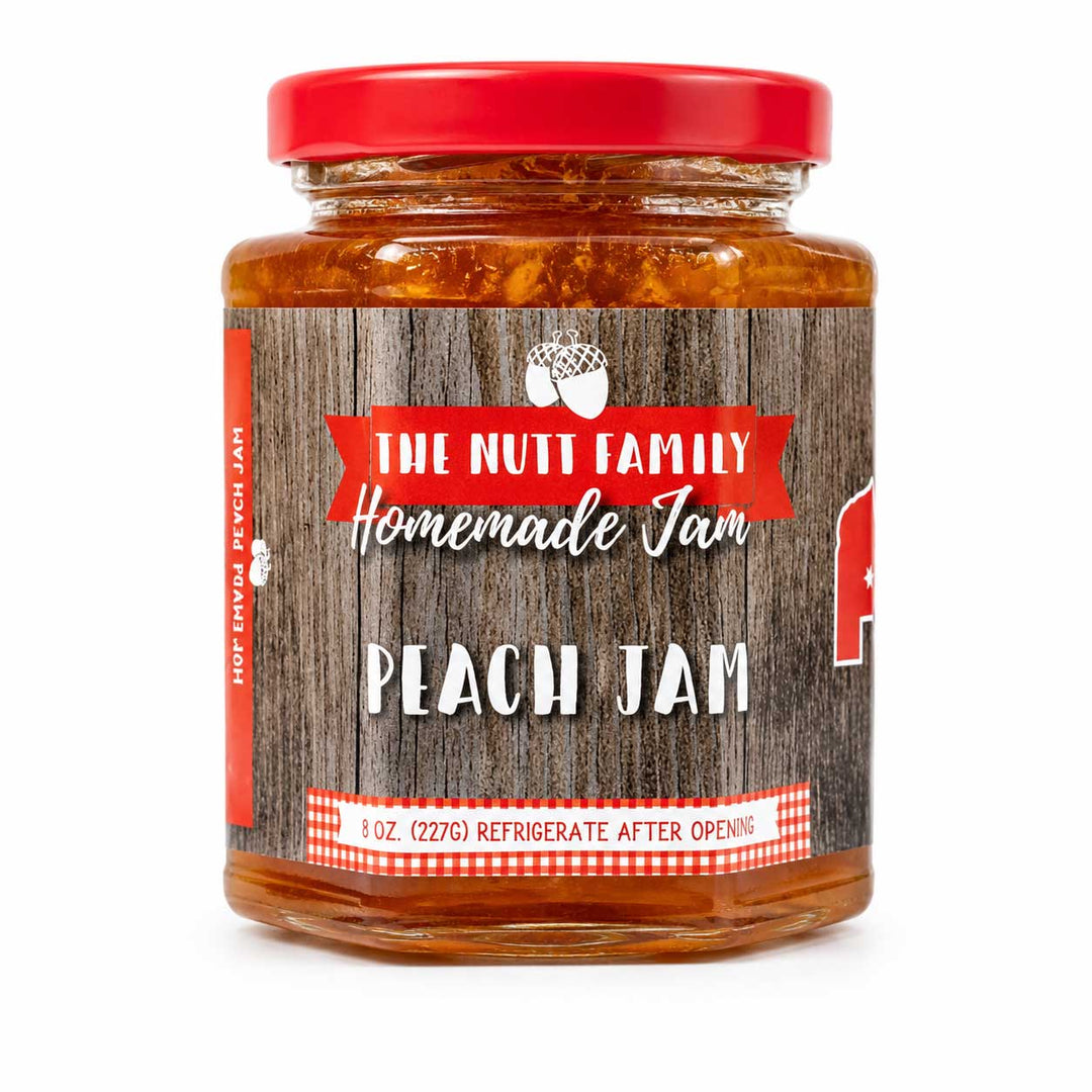 Jar of peach jam with a red lid and wooden-textured label on a white background