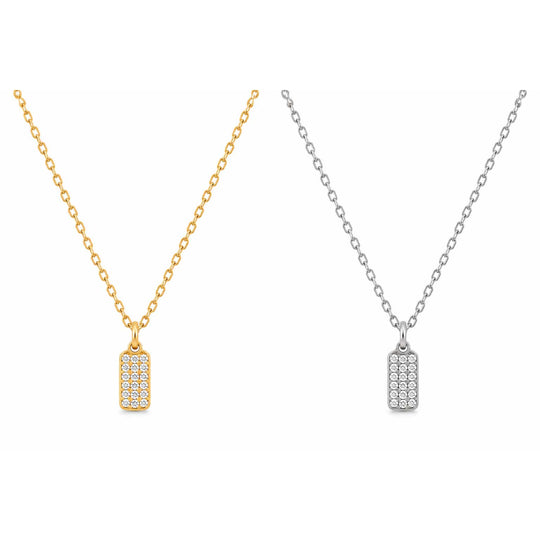 Two rectangular dog-tag style necklaces with pavé-set clear stones, shown side by side on a white background. One necklace has a gold chain and pendant, and the other has a silver chain and pendant.
