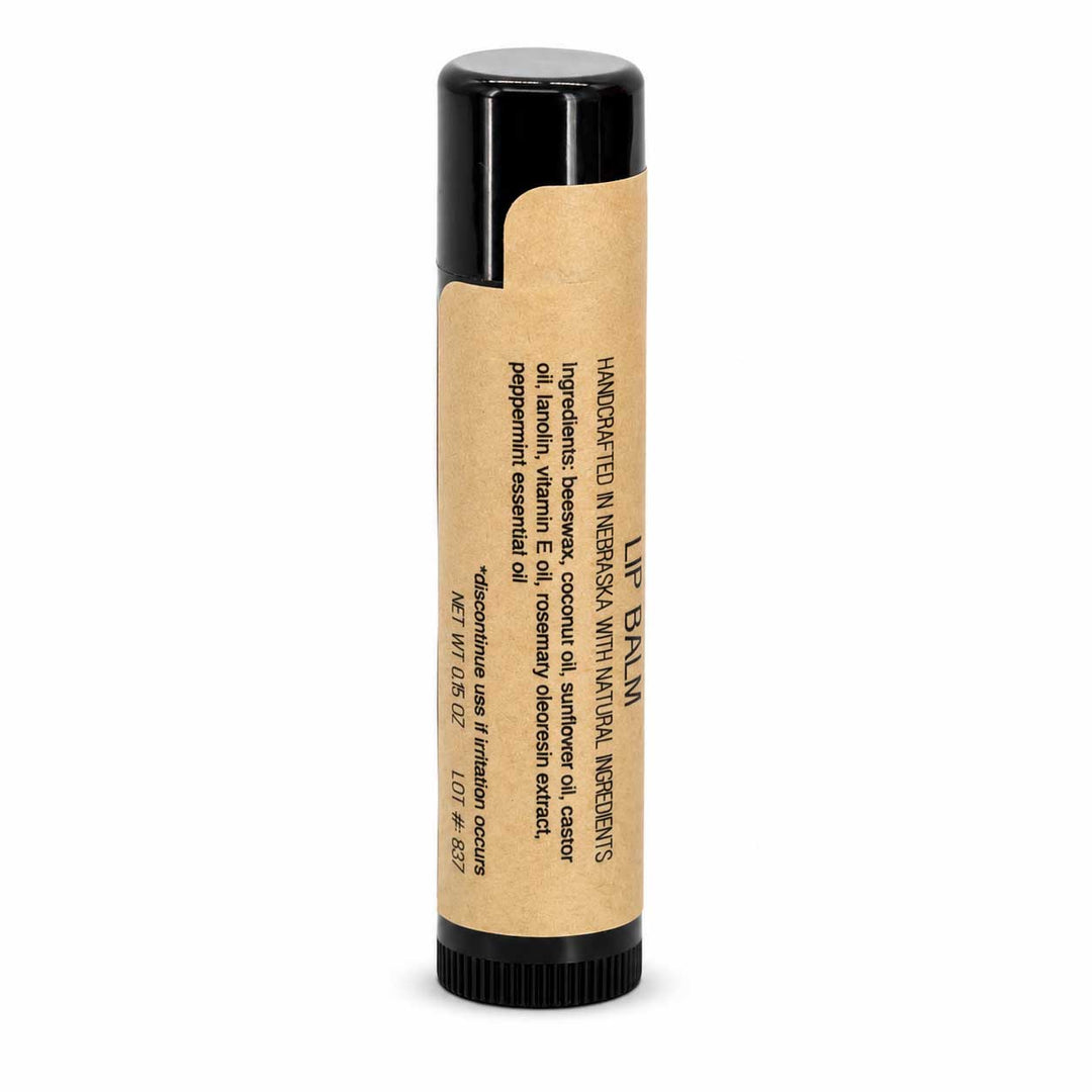 Lip balm with a black cap and kraft paper wrapper on a white background