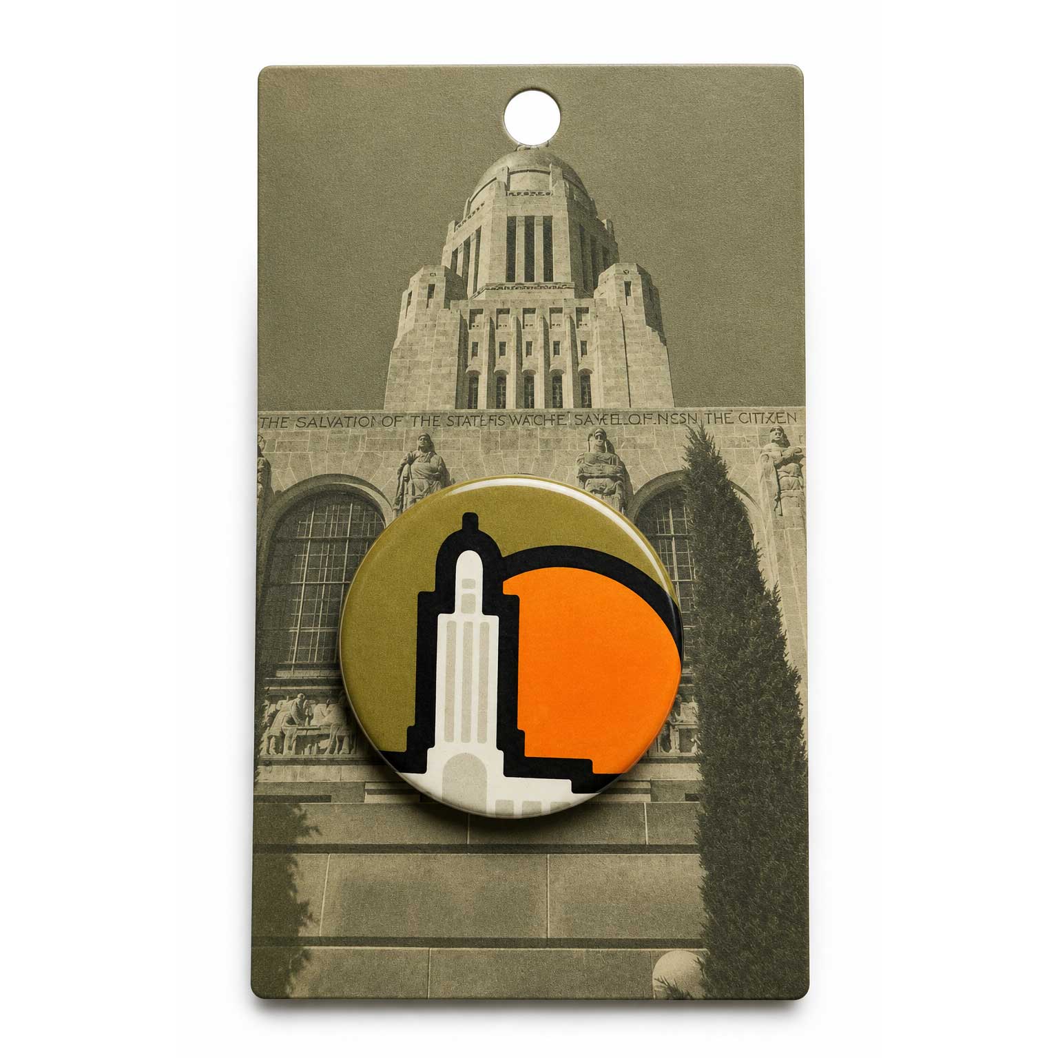 A round pin-back button badge featuring a stylized white tower icon on a gold background with a large orange semi-circle, displayed on a printed backing card showing a sepia-toned building facade.