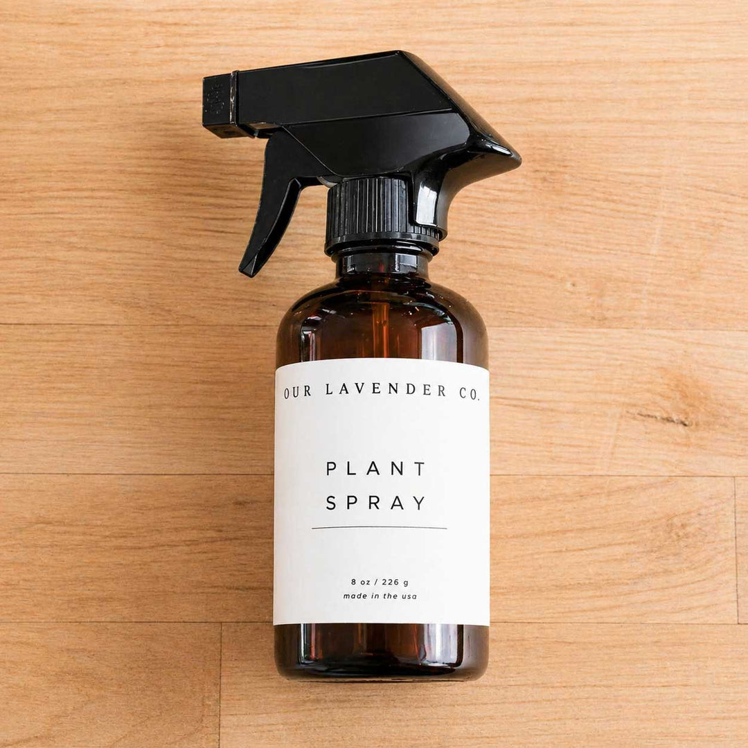 Brown spray bottle labeled 'Our Lavender Co. Plant Spray' on a wooden surface