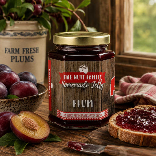 Jar of plum jelly with a rustic label on a wooden table with plums and bread.