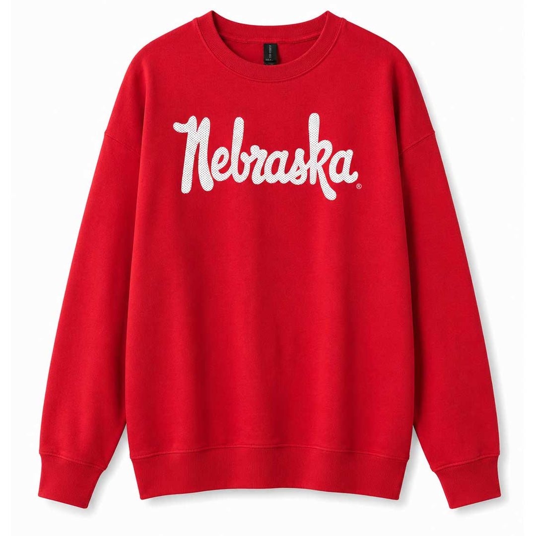 A bright red crewneck sweatshirt featuring the word 'Nebraska' printed across the chest in a white cursive script, displayed against a clean white background.