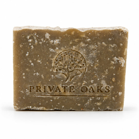 A rectangular bar of handmade soap in a warm brownish-tan color with white speckles, embossed with a tree logo and the brand name 'PRIVATE OAKS' on a white background.