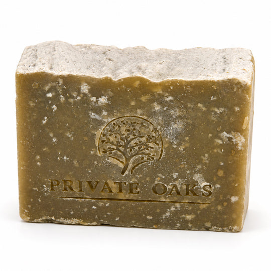 A rectangular bar of handmade soap with a rustic, rough-textured surface, embossed with a tree logo and the brand name 'PRIVATE OAKS' on a plain white background.