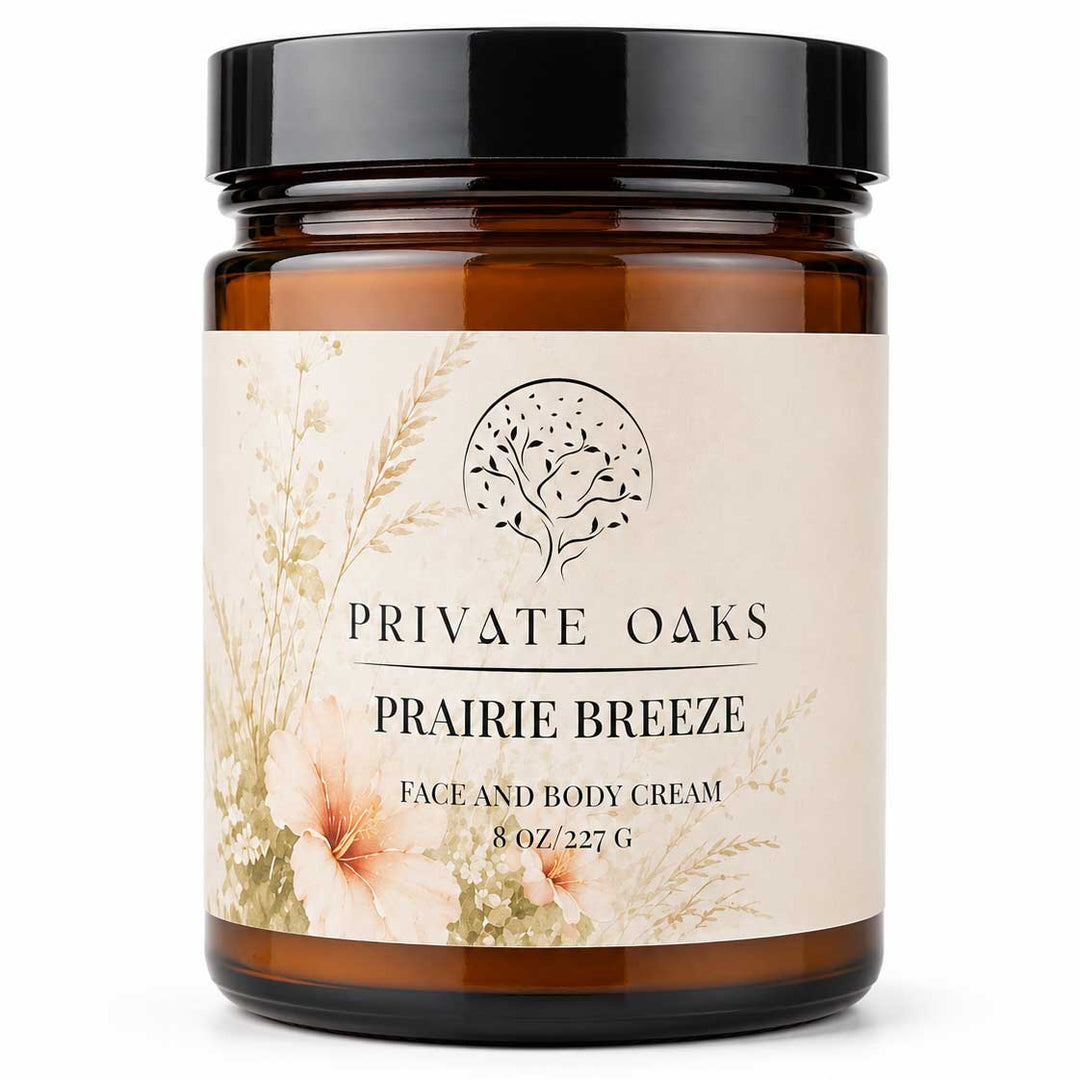 An 8 oz amber glass jar of Private Oaks Prairie Breeze Face and Body Cream with a black lid and a beige floral label, set against a plain white background.
