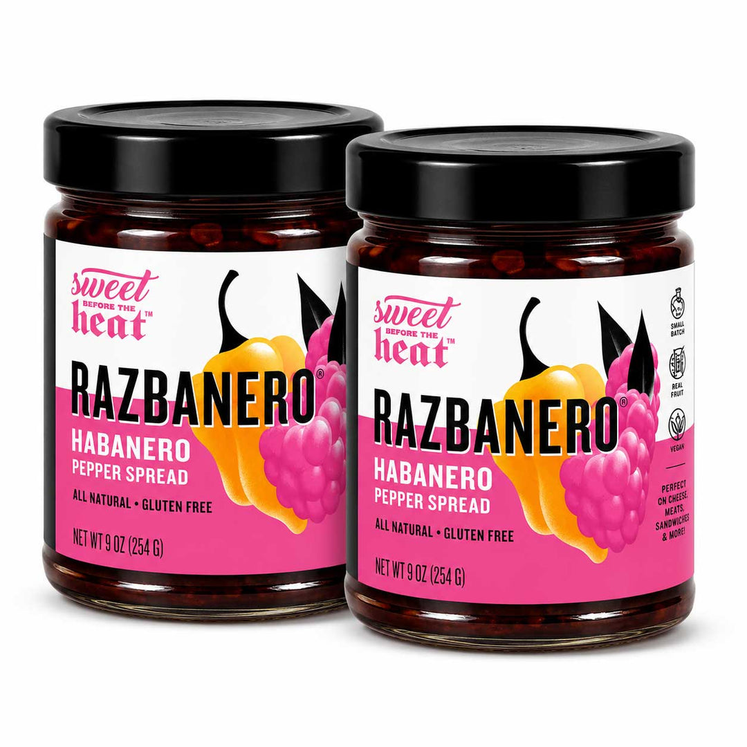 Two glass jars of Sweet Heat RAZBANERO Habanero Pepper Spread with black lids, displayed on a clean white background.
