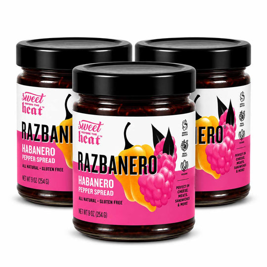 Three glass jars of Sweet Heat RAZBANERO Habanero Pepper Spread arranged in a group on a white background.