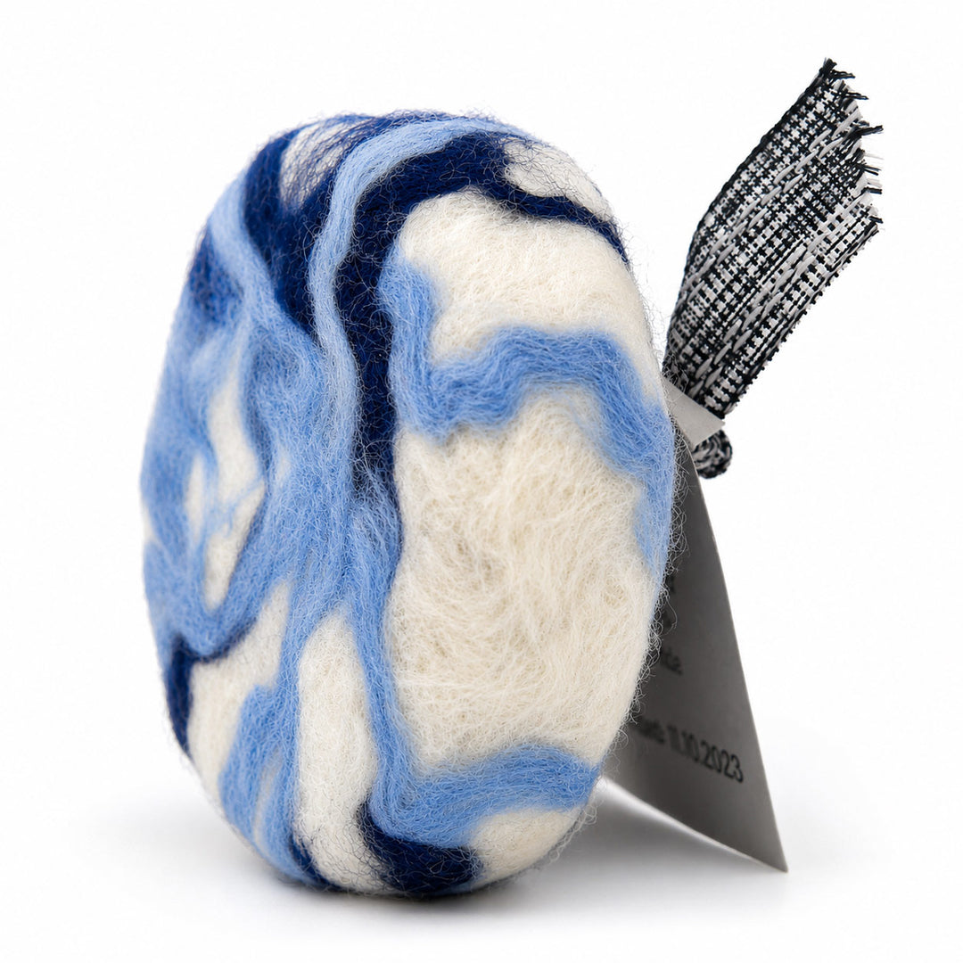 Blue and white marbled hair product with a black brush on a white background