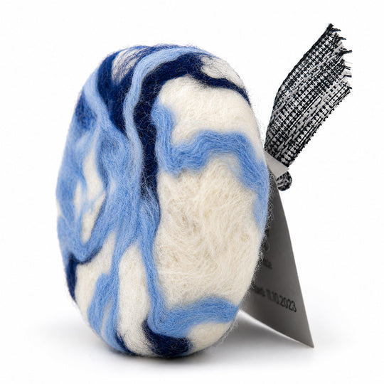 Blue and white marbled hair product with a black brush on a white background