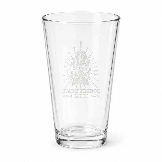 A clear glass pint glass with a frosted gray etched design featuring a lantern and the text 'Robber's Cave Tours' on a plain white background.