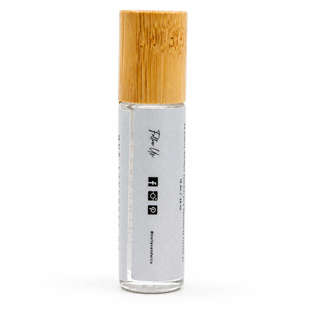 Clear glass roller bottle with a wooden cap on a white background