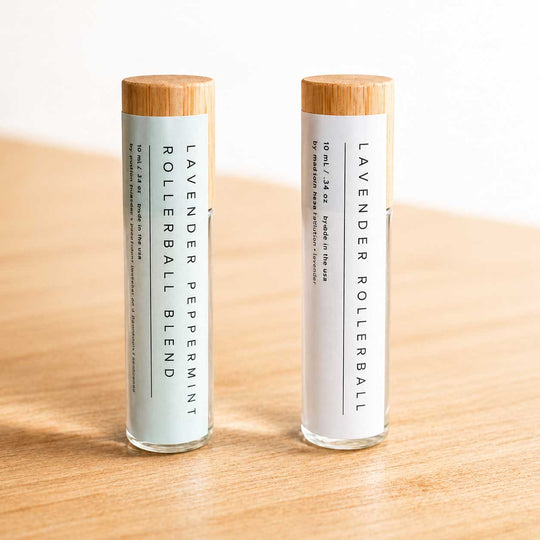 Two lavender rollerball blends on a wooden surface