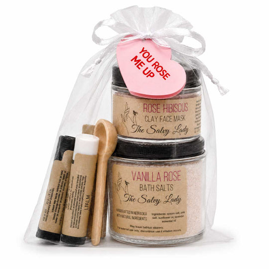 Gift set with 'The Salty Lady' products including jars, a tube, and a heart-shaped card on a white background.