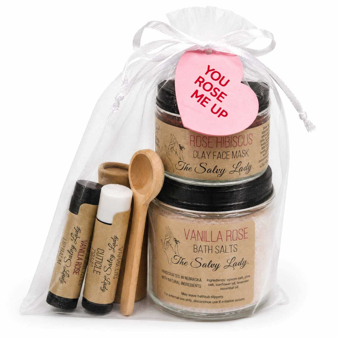 Gift set with 'The Salty Lady' products including jars, a tube, and a heart-shaped card on a white background.